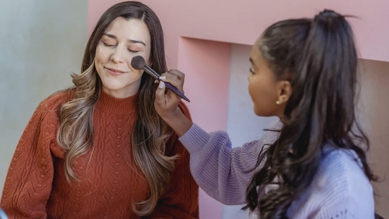 Woman Applying Flawless Foundation on Friend's Face