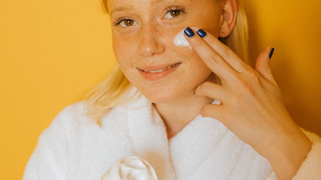 woman applying moisturizer on her skin