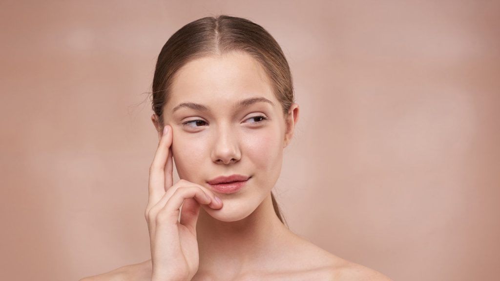 woman holding her flawless skin