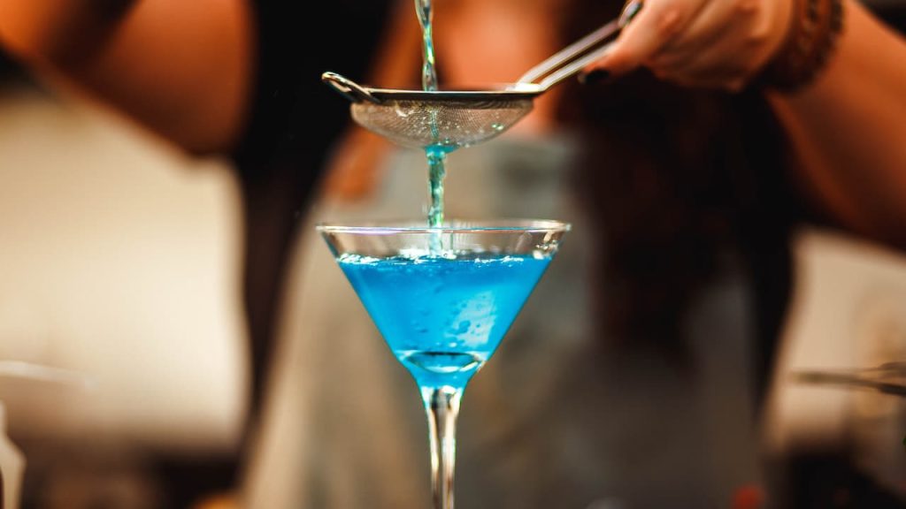 a glass of blue cocktail