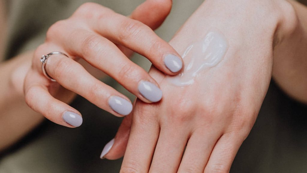 woman applying sunscreen on hand