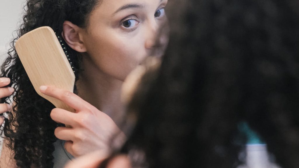 woman brushing curly hair