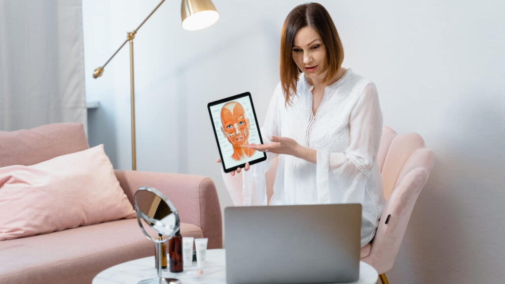 Woman Showing a Picture of the Anatomy of Face Muscles