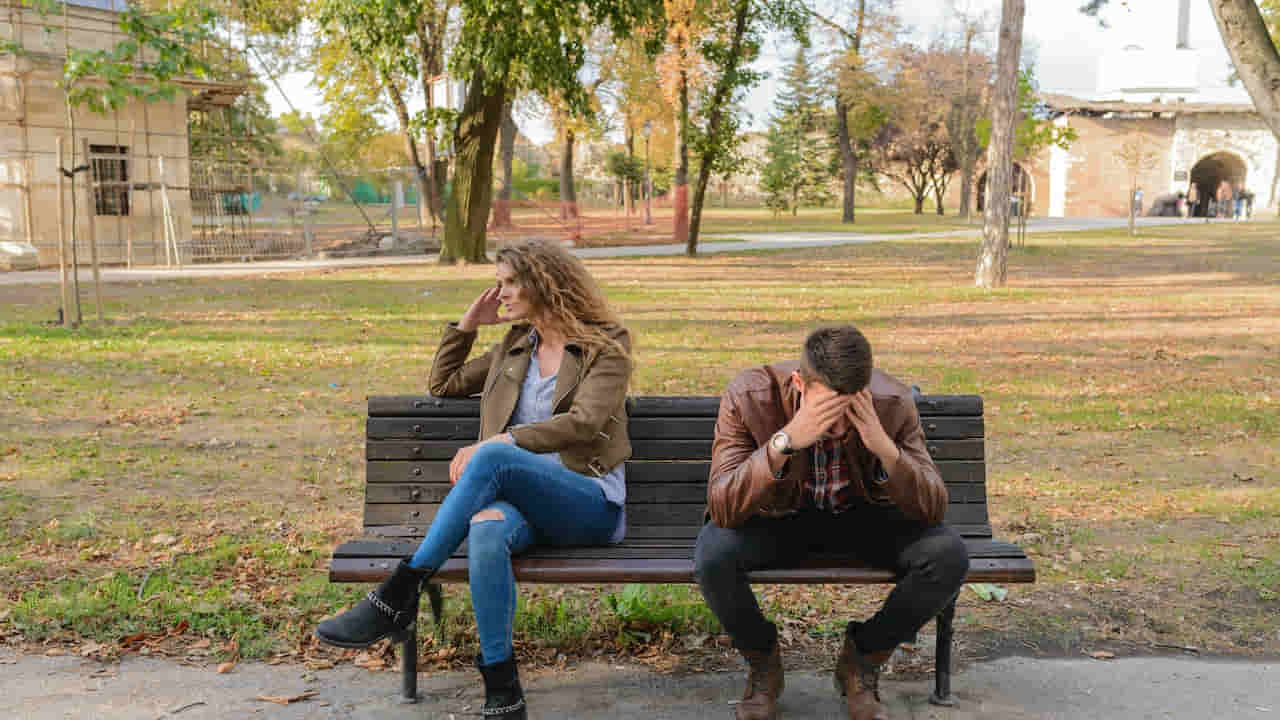 Woman And Man Sitting on Brown Wooden Bench