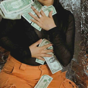 Young woman with money sitting on floor