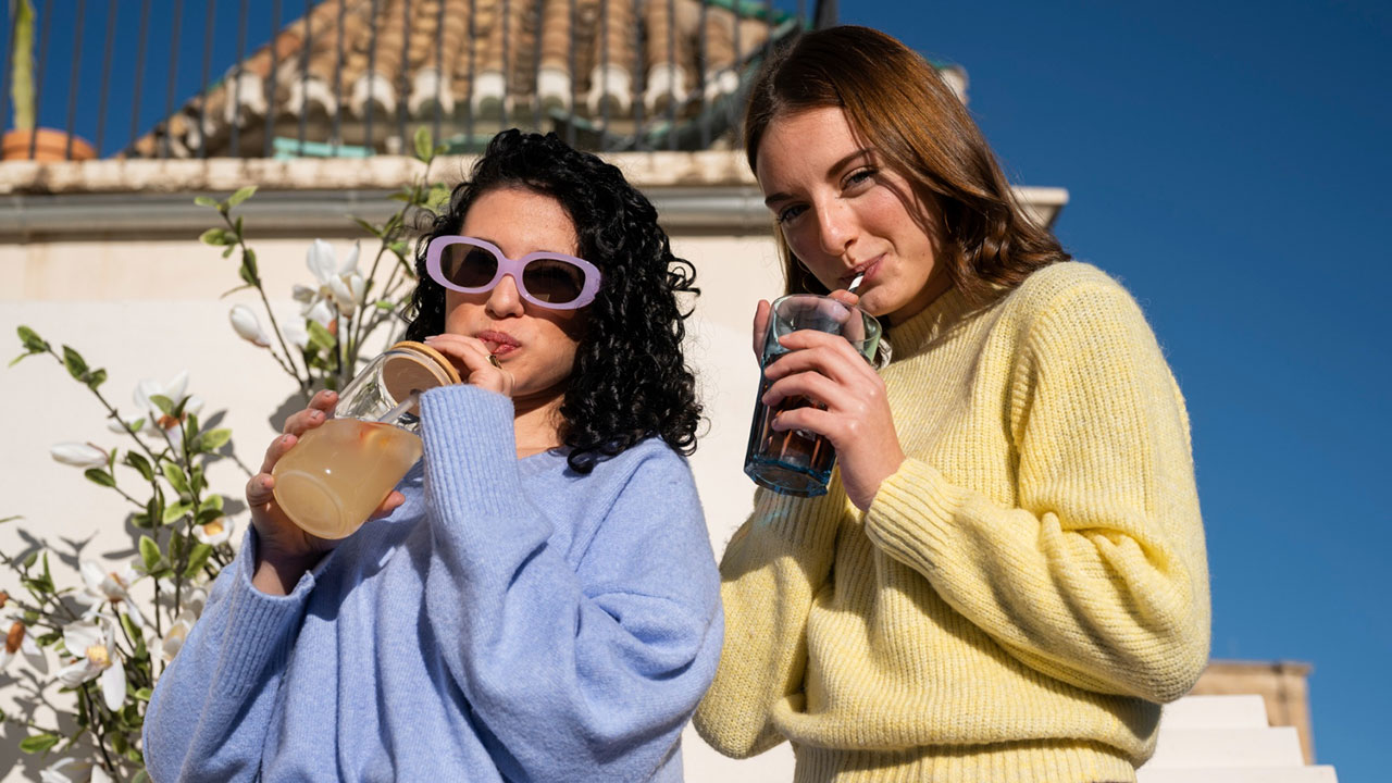 Girls are sipping brews and enjoying them. 