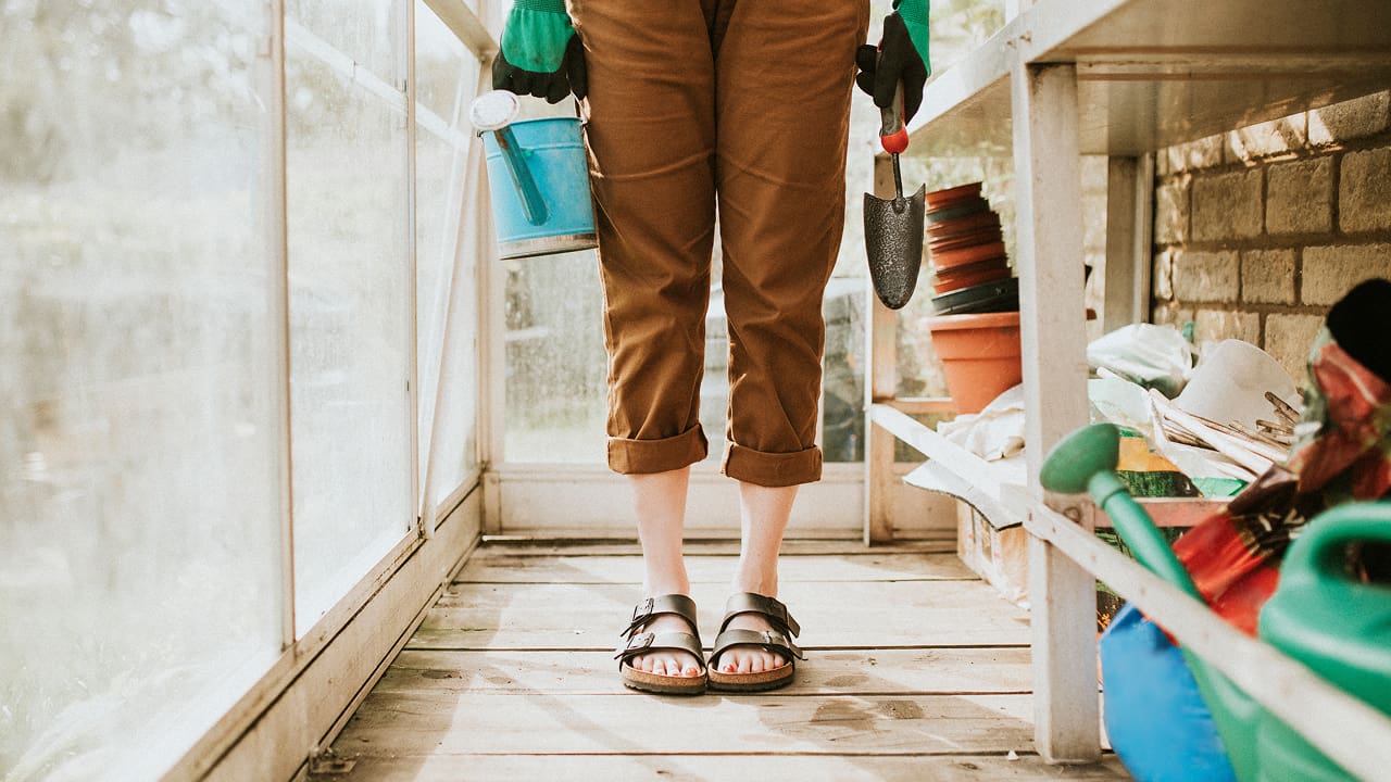 A woman holding gardening tools
